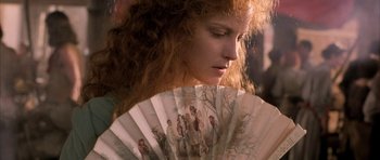 Movie still from “The Wings of the Dove” (1997), directed by Iain Softley – A person holding a hand held fan; Close Up shot, Over the shoulder angle