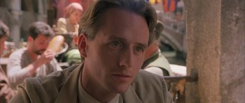 Movie still from “The Wings of the Dove” (1997), directed by Iain Softley – A person wearing a suit and tie; Close Up shot, Over the shoulder angle