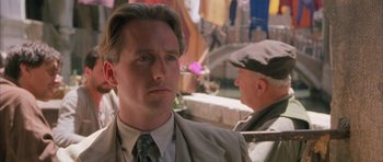 Movie still from “The Wings of the Dove” (1997), directed by Iain Softley – A person wearing a suit and hat; Close Up shot, Over the shoulder angle