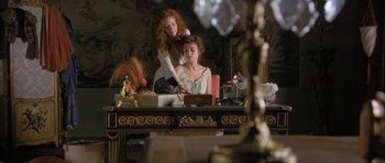 Movie still from “The Wings of the Dove” (1997), directed by Iain Softley – Two women sitting in front of each other in front of a mirror; Medium shot, High angle