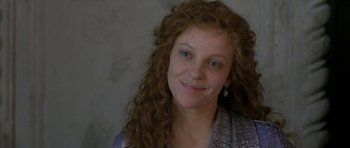 Movie still from “The Wings of the Dove” (1997), directed by Iain Softley – A person with curly hair smiling; Close Up shot, High angle
