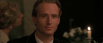 Movie still from “The Wings of the Dove” (1997), directed by Iain Softley – A person wearing a suit and tie; Close Up shot, Over the shoulder angle