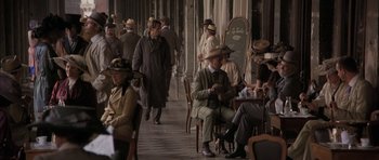 Movie still from “The Wings of the Dove” (1997), directed by Iain Softley – A group of people sitting at tables in a restaurant; Wide shot, High angle