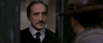 Movie still from “The Wings of the Dove” (1997), directed by Iain Softley – A person wearing a suit and a tie; Close Up shot, Over the shoulder angle