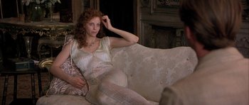 Movie still from “The Wings of the Dove” (1997), directed by Iain Softley – A woman sitting on top of a white couch; Medium shot, High angle