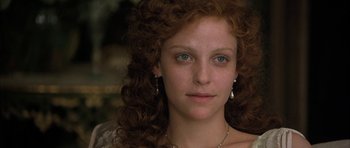 Movie still from “The Wings of the Dove” (1997), directed by Iain Softley – A person with curly hair wearing a necklace; Close Up shot, High angle