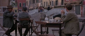 Movie still from “The Wings of the Dove” (1997), directed by Iain Softley – People are sitting at a table in an outdoor cafe; Wide shot, High angle