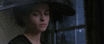 Movie still from “The Wings of the Dove” (1997), directed by Iain Softley – A woman wearing a black dress and a black hat; Close Up shot, Over the shoulder angle