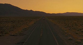 Movie still from “The Wizard” (1989), directed by Todd Holland – A car is driving down the road at sunset; Extreme Wide shot, High angle