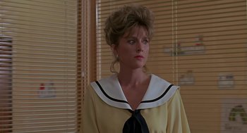 Movie still from “The Wizard” (1989), directed by Todd Holland – A woman in a yellow dress with a black tie; Close Up shot, Over the shoulder angle