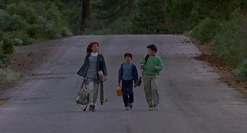 Movie still from “The Wizard” (1989), directed by Todd Holland – A woman and two children walking down a road; Wide shot, Low angle