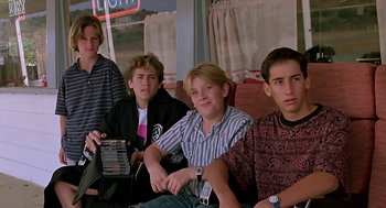 Movie still from “The Wizard” (1989), directed by Todd Holland – A group of young men sitting next to each other on a couch; Medium shot, Low angle