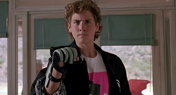 Movie still from “The Wizard” (1989), directed by Todd Holland – A young man holding a pair of gloves in his hand; Close Up shot, Low angle