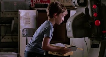 Movie still from “The Wizard” (1989), directed by Todd Holland – A young boy is looking at a piece of paper; Medium shot, Over the shoulder angle