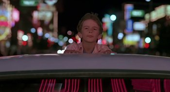 Movie still from “The Wizard” (1989), directed by Todd Holland – A young boy sitting in front of a neon sign at night; Close Up shot, Low angle