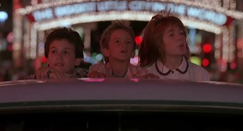 Movie still from “The Wizard” (1989), directed by Todd Holland – Three children looking out of a window at a carnival; Close Up shot, Low angle