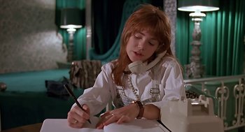Movie still from “The Wizard” (1989), directed by Todd Holland – A girl is writing on a piece of paper while talking on the phone; Medium shot, Low angle