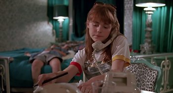 Movie still from “The Wizard” (1989), directed by Todd Holland – A young girl sitting at a table talking on the phone; Medium shot, Low angle