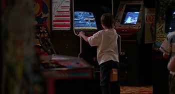 Movie still from “The Wizard” (1989), directed by Todd Holland – A young boy playing a video game in an arcade; Wide shot, Over the shoulder angle