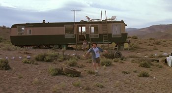 Movie still from “The Wizard” (1989), directed by Todd Holland – A young boy is running in the dirt near an rv; Extreme Wide shot, Low angle