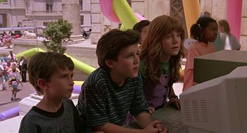 Movie still from “The Wizard” (1989), directed by Todd Holland – A group of young people sitting at a table looking at a computer screen; Medium shot, Over the shoulder angle