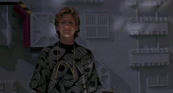 Movie still from “The Wizard” (1989), directed by Todd Holland – A young man wearing headphones in front of a wall; Medium shot, Low angle