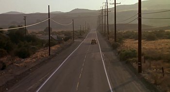 Movie still from “The Wizard” (1989), directed by Todd Holland – A car driving down the middle of a road; Extreme Wide shot, High angle