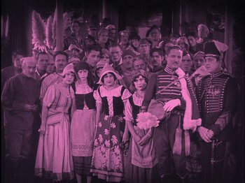 Movie still from “The Wizard of Oz” (1925), directed by Larry Semon – A group of people standing in a room together; Wide shot, High angle