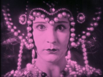 Movie still from “The Wizard of Oz” (1925), directed by Larry Semon – A woman wearing pearls and wearing a crown; Close Up shot, Low angle