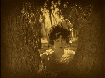Movie still from “The Wizard of Oz” (1925), directed by Larry Semon – An old photo of a woman in a forest; Medium shot, High angle
