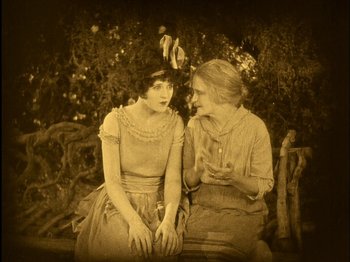Movie still from “The Wizard of Oz” (1925), directed by Larry Semon – Two women sitting next to each other on a bench; Medium shot, High angle