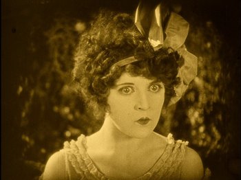 Movie still from “The Wizard of Oz” (1925), directed by Larry Semon – An old photo of a woman with a bow in her hair; Close Up shot, High angle
