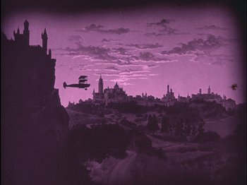 Movie still from “The Wizard of Oz” (1925), directed by Larry Semon – An airplane flying over a city at night; Extreme Wide shot, Low angle