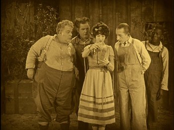 Movie still from “The Wizard of Oz” (1925), directed by Larry Semon – A group of people standing next to each other; Wide shot, High angle