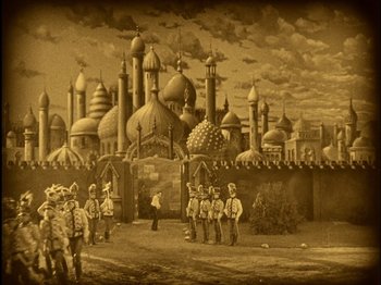Movie still from “The Wizard of Oz” (1925), directed by Larry Semon – An old painting of a city with many domes; Extreme Wide shot, High angle