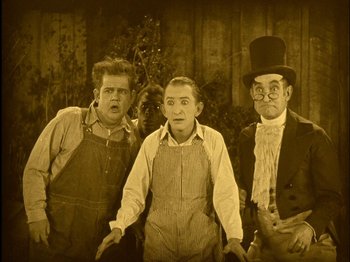 Movie still from “The Wizard of Oz” (1925), directed by Larry Semon – A group of men standing next to each other; Medium shot, High angle