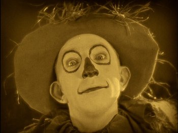 Movie still from “The Wizard of Oz” (1925), directed by Larry Semon – A man with a hat and face paint on; Extreme Close Up shot, High angle