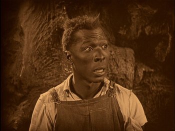 Movie still from “The Wizard of Oz” (1925), directed by Larry Semon – An old photo of an african american man looking surprised; Close Up shot, High angle