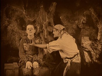 Movie still from “The Wizard of Oz” (1925), directed by Larry Semon – Two men in costumes one of which is pointing at another man; Medium shot, High angle