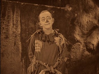 Movie still from “The Wizard of Oz” (1925), directed by Larry Semon – An old photo of a man dressed as a scarecrow; Medium shot, High angle