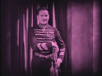 Movie still from “The Wizard of Oz” (1925), directed by Larry Semon – A man dressed in a uniform holding a gun; Medium shot, Low angle