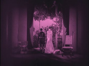 Movie still from “The Wizard of Oz” (1925), directed by Larry Semon – Two people standing in front of an open window; Wide shot, High angle