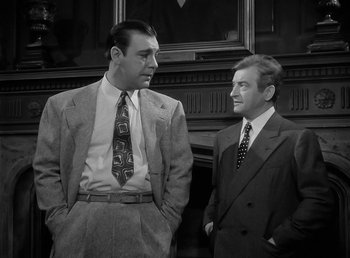 Movie still from “The Wolf Man” (1941), directed by George Waggner – A black and white photo of two men standing next to each other; Medium shot, Low angle