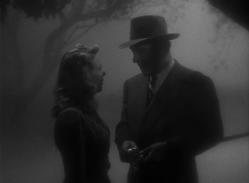 Movie still from “The Wolf Man” (1941), directed by George Waggner – A man and a woman standing next to each other in the fog; Close Up shot, High angle