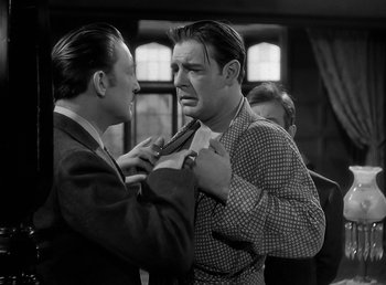Movie still from “The Wolf Man” (1941), directed by George Waggner – A man is tying a tie on another man's neck tie; Medium shot, Over the shoulder angle