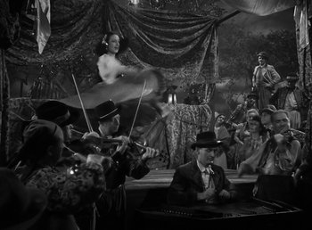 Movie still from “The Wolf Man” (1941), directed by George Waggner – A black and white photo of a group of people playing music; Wide shot, Low angle