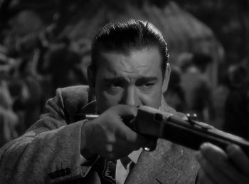 Movie still from “The Wolf Man” (1941), directed by George Waggner – A black and white photo of a man holding a gun; Close Up shot, Over the shoulder angle