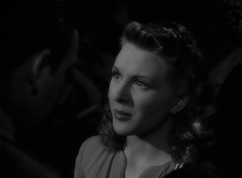 Movie still from “The Wolf Man” (1941), directed by George Waggner – A black - and - white photo of a woman in a dress; Close Up shot, Over the shoulder angle