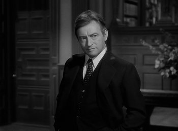 Movie still from “The Wolf Man” (1941), directed by George Waggner – Black and white photograph of a man wearing a suit and tie; Close Up shot, Low angle