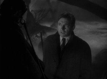 Movie still from “The Wolf Man” (1941), directed by George Waggner – A black and white photo of a man in a suit and tie; Close Up shot, Over the shoulder angle